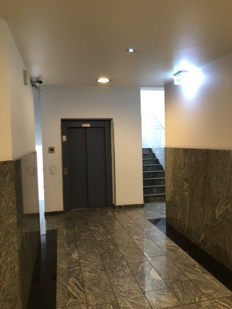 Hier siehst du das Treppenhaus und den Aufzugbereich, der zur Praxis für Psychotherapie Würzburg der Dipl.-Psych. Evi Kühnlein führt.